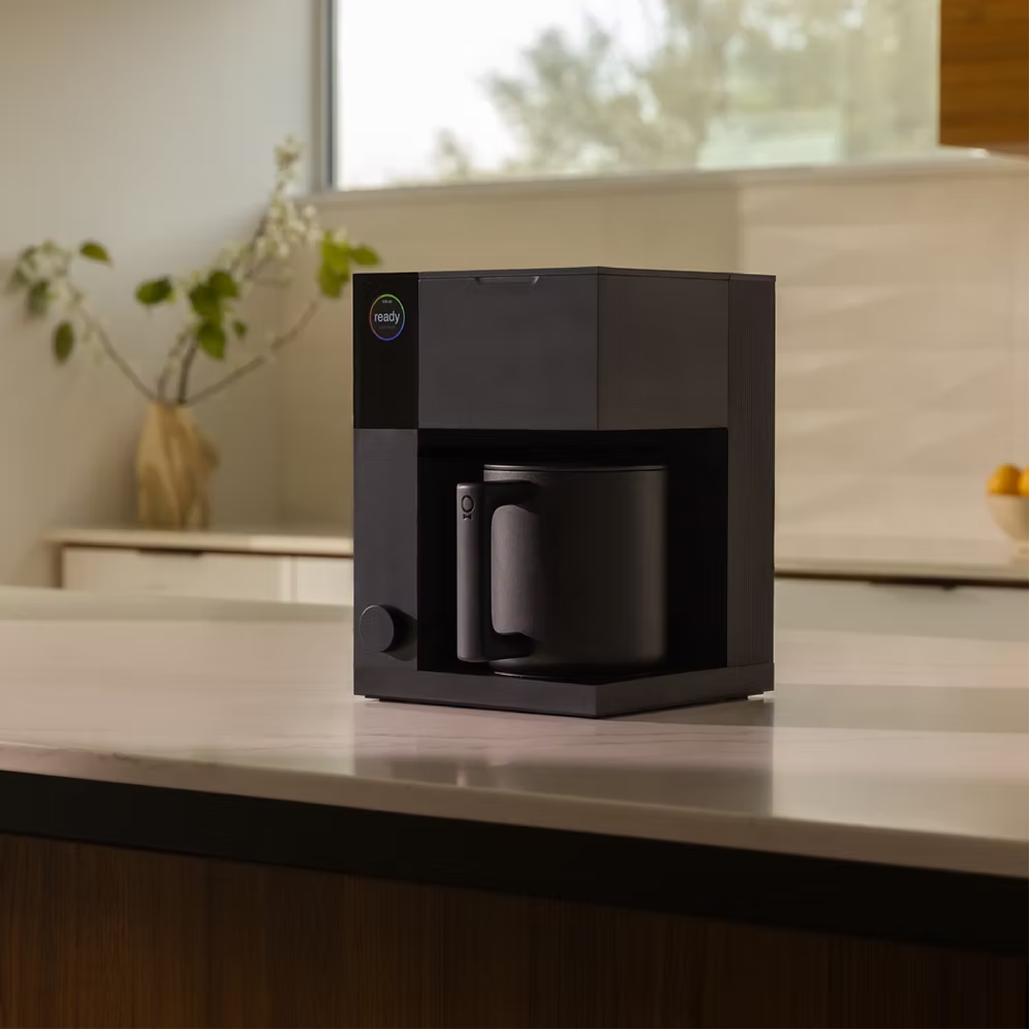 Fellow Aiden Precision Coffee Maker in matte black with thermal carafe. Diagonal view of the machine on a countertop.