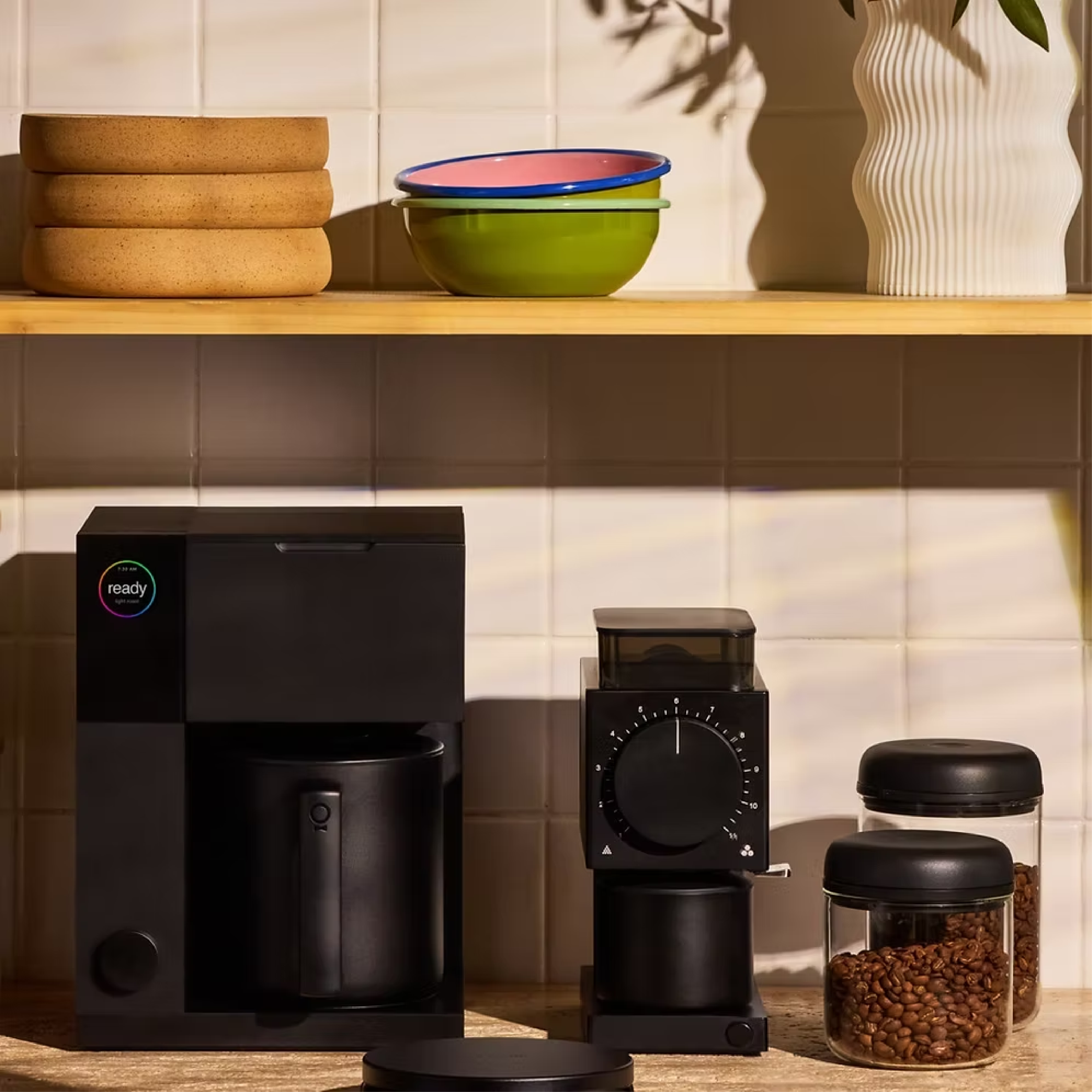 Fellow Aiden Precision Coffee Maker in matte black with thermal carafe. Ode Gen 2 Grinder and Atmos Vacuum Canisters in black on the side.