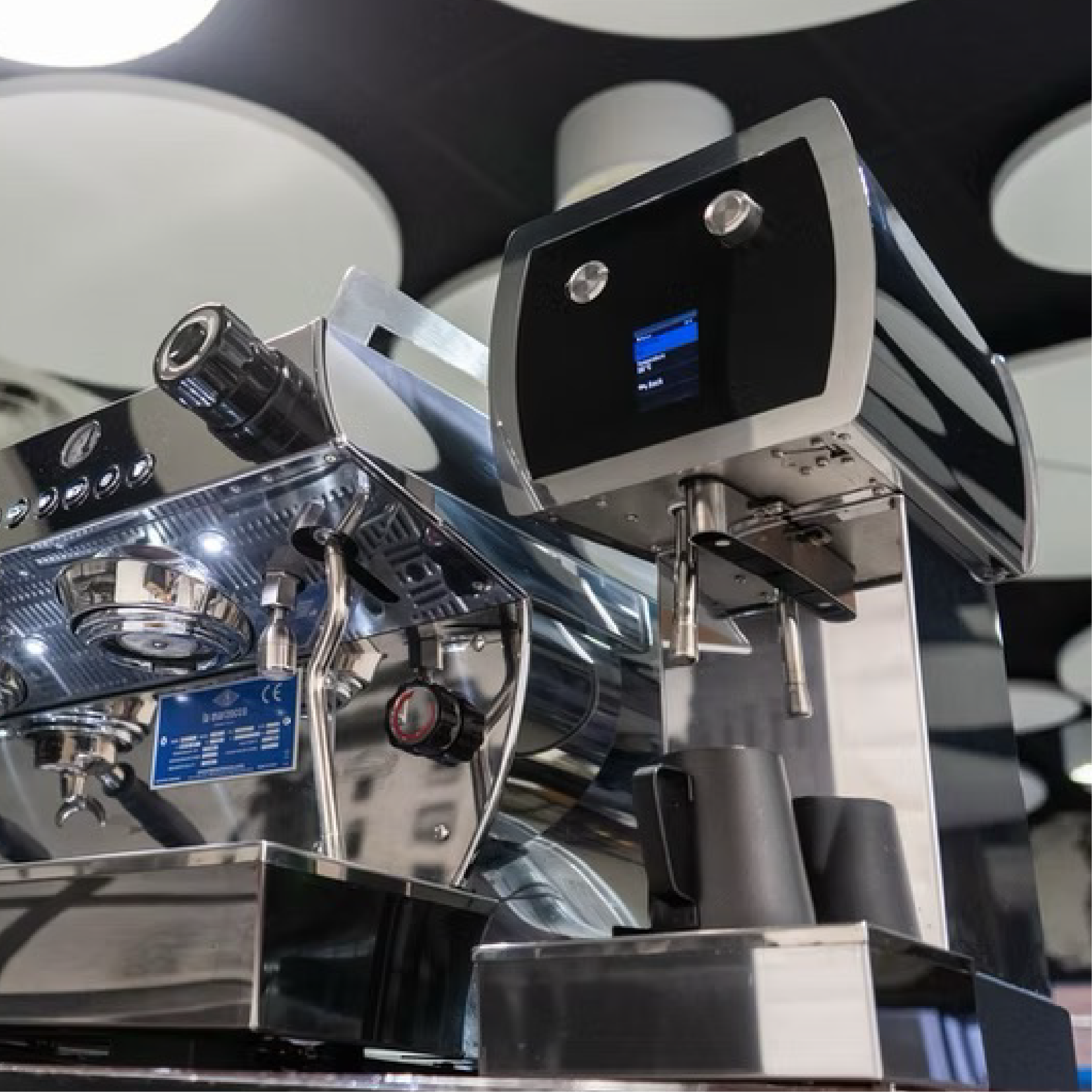 La Marzocco Wally Automatic Milk Steamer. Bottom up view of the machine placed next to an espresso machine.