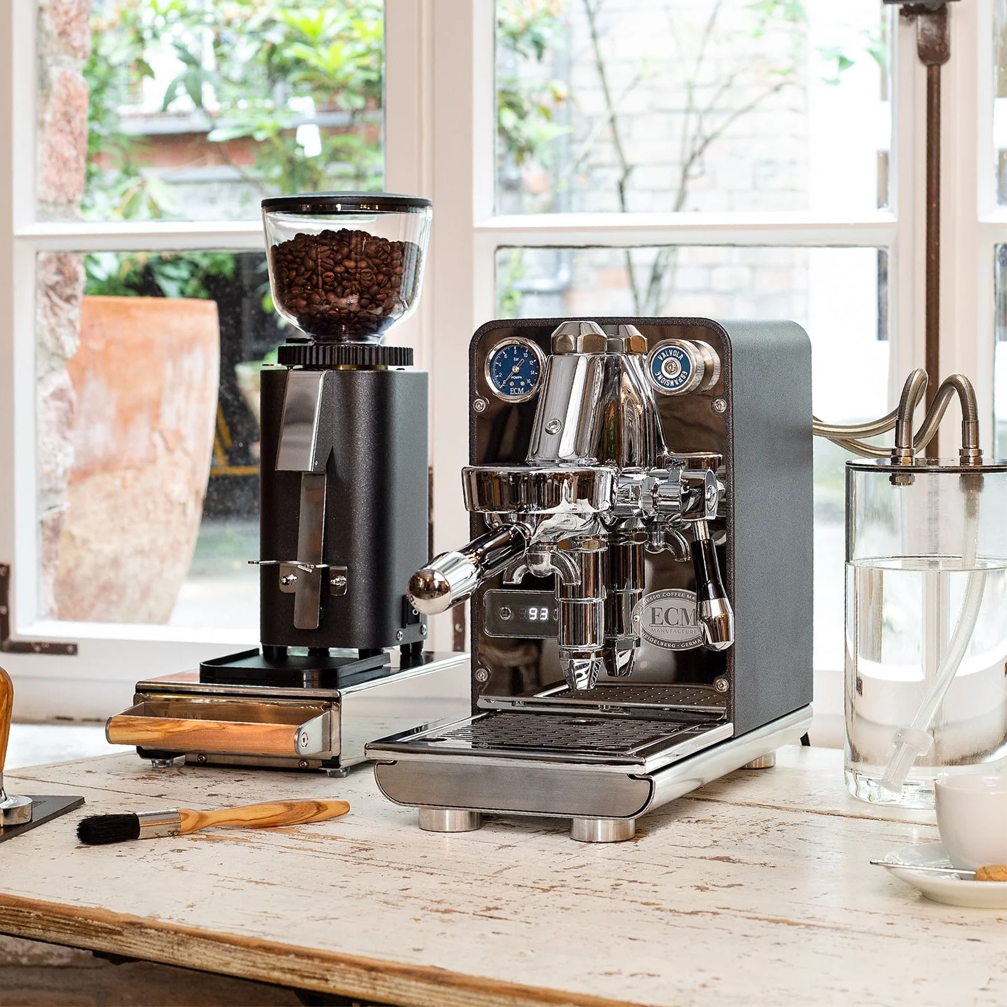 ECM Puristika Espresso Machine. Side view of the machine with glass water tank on the right side on the countertop.