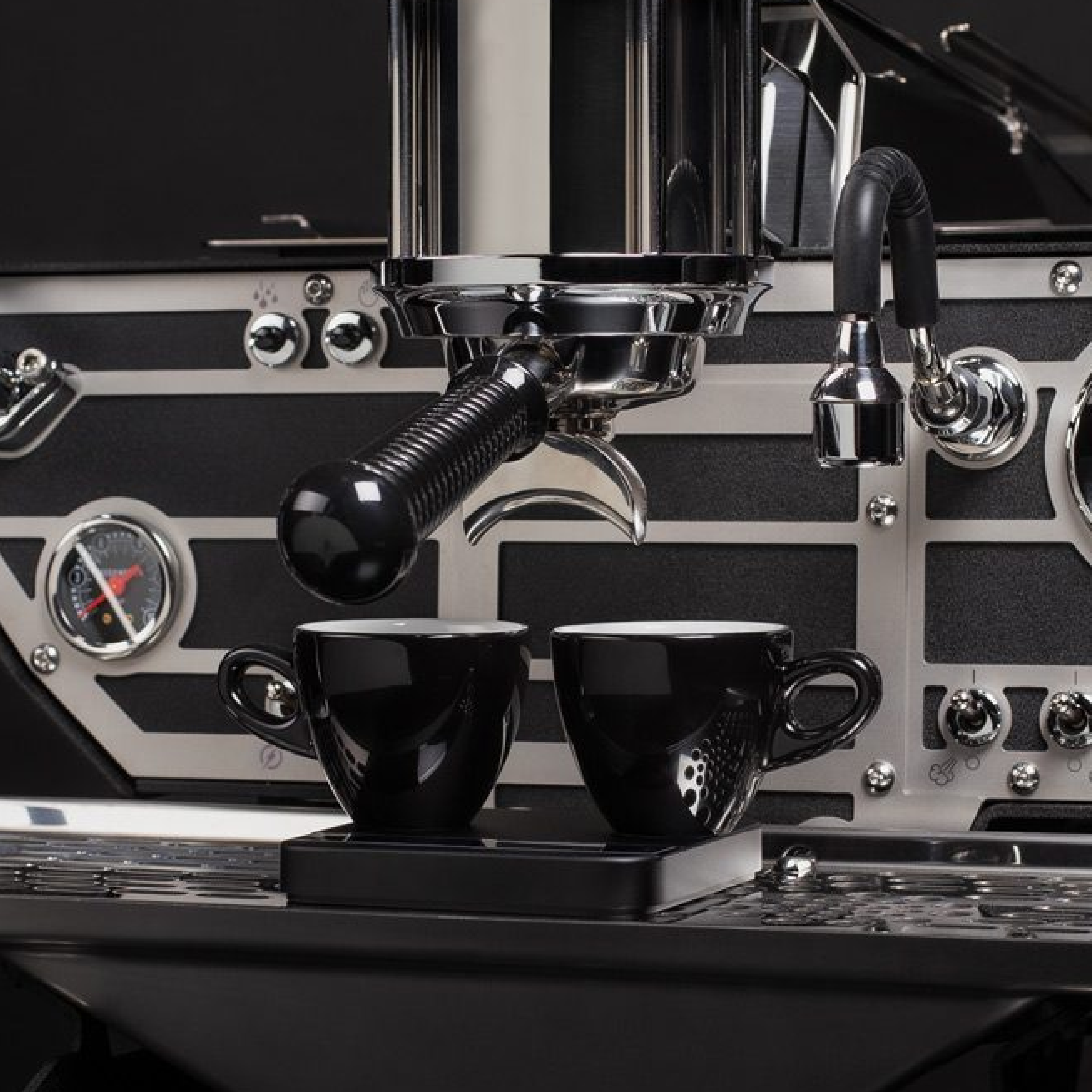 Kees Van Der Westen Spiritello. Close up of the grouphead with a double spout portafilter and 2 espresso cups on a scale.