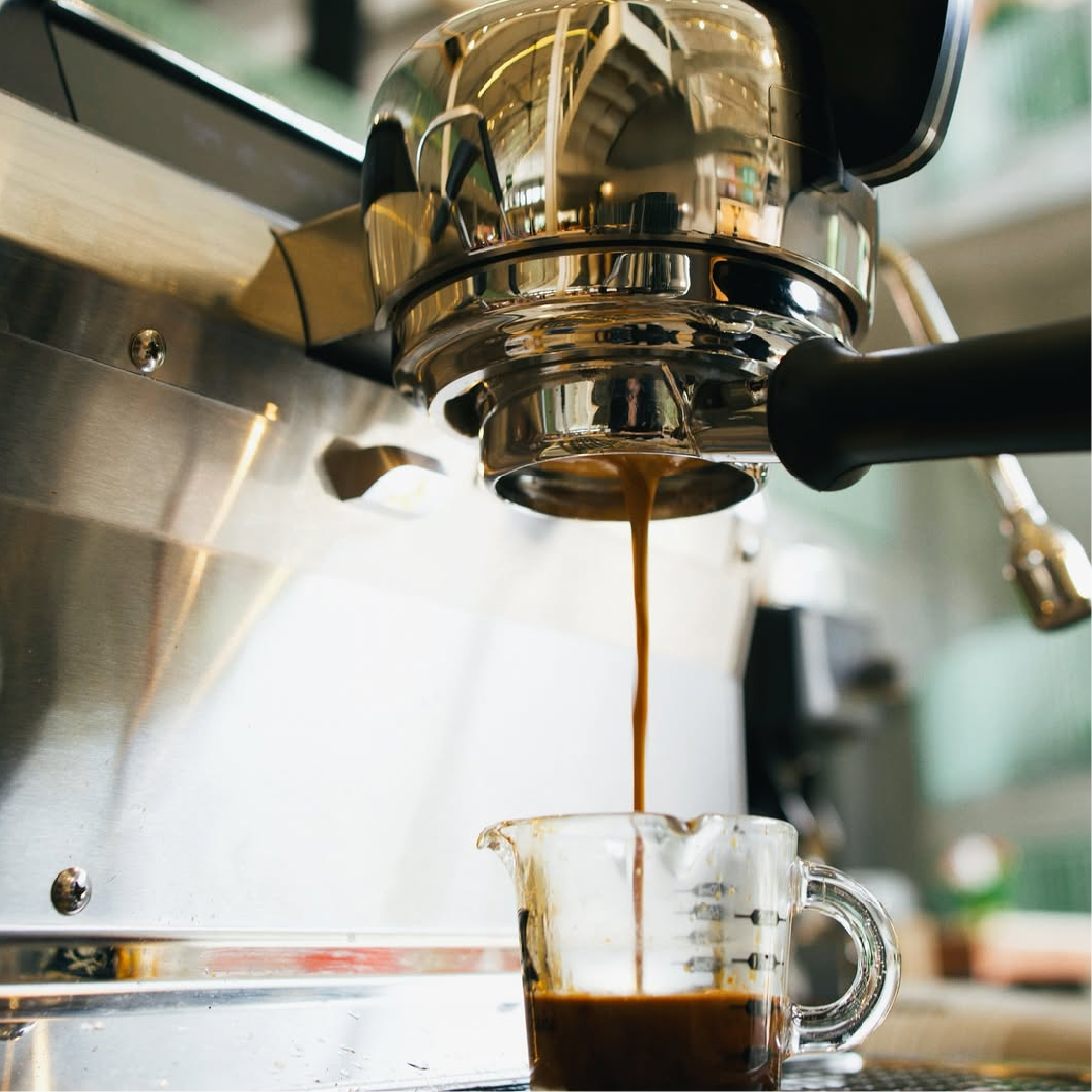 Slayer Steam Single Group Espresso Machine. Close up of espresso extraction from portafilter into a glass measuring cup.