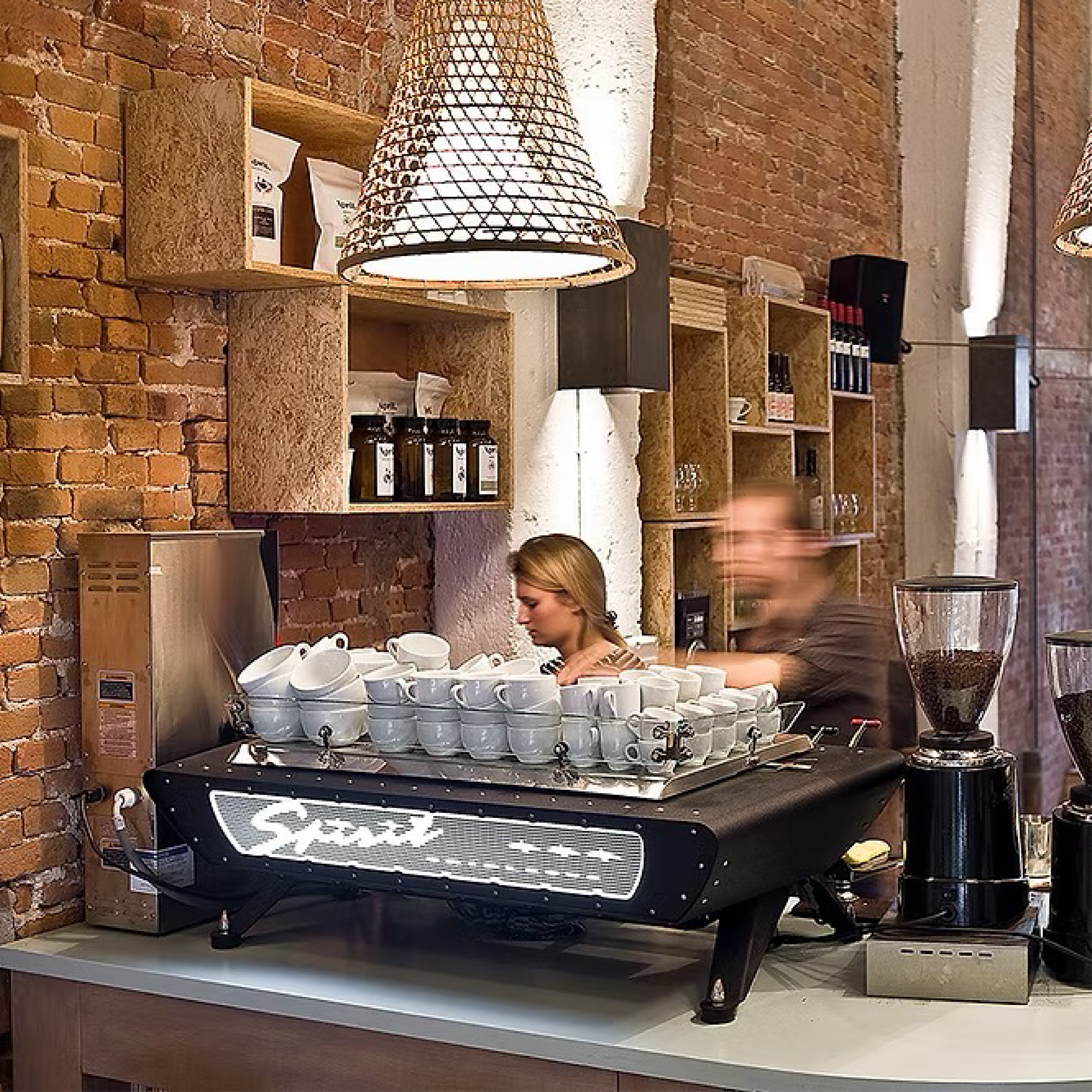 Kees Van Der Westen Spirit Triplette. Front view of the machine with crackle black body, crackle black frame and crackle black cup tray on a countertop. 